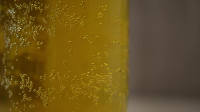 Blonde beer close up background. Bubbles of air carbon dioxide in beer float to the top. Glowing light golden ale with effervescence in a full frame background texture for for beer, brewery
