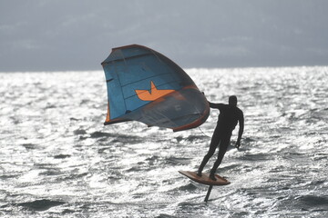a man riding a kite board on top of a large body of water