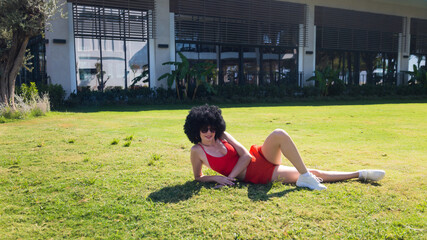 Fototapeta premium Athletic girl resting lying grass after physical exercise.
