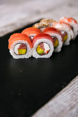 Close up delicious sushi set on black plate over dark background
