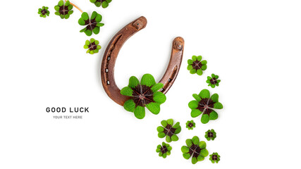 Old horseshoe and four leaf clover composition isolated on white background.