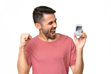 Young handsome caucasian man holding a engagement ring over isolated background celebrating a victory