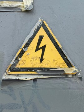 High voltage warning sign on a metal background, closeup of photo