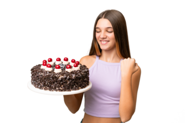 Teenager caucasian girl holding birthday cake over isolated background celebrating a victory