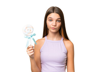 Teenager caucasian girl holding a lollipop over isolated background with sad expression