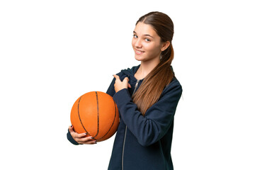 Teenager caucasian girl playing basketball over isolated background pointing back