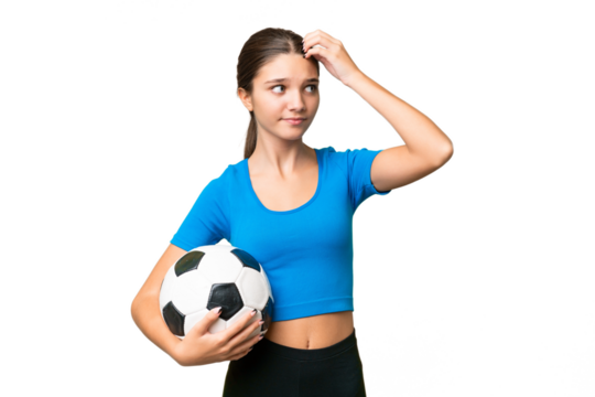 Teenager caucasian girl playing football over isolated background having doubts and with confuse face expression