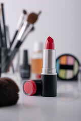 Dressing table with decorative cosmetics and red lipstick on foreground