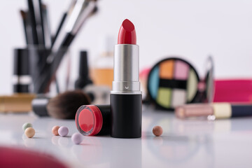 Dressing table with decorative cosmetics and red lipstick on foreground