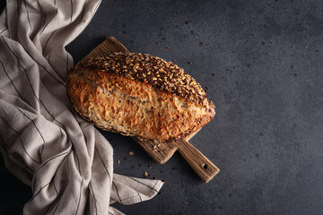Organic homemade whole grain bread on wooden cutting board.