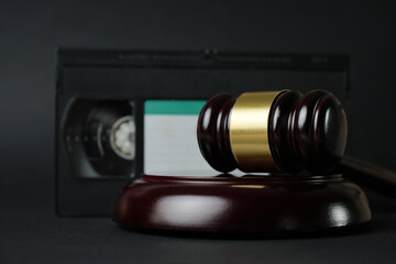 Video copyright law concept. VHS cassette tape and judge gavel