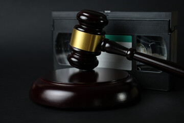 Video copyright law concept. VHS cassette tape and judge gavel