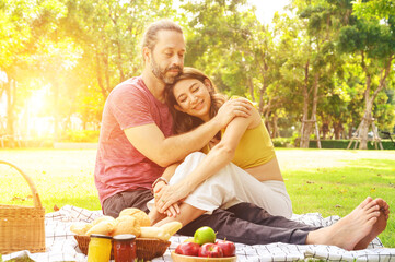 Picnic time. Happy couple relaxing on blanket enjoying picnic in sunny garden. Love and tenderness, dating, romance. Lifestyle concept.