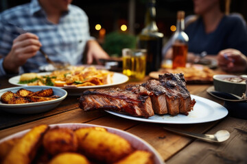 People enjoying a delicious meal, grilled pork ribs with roasted potatoes while dining out - obrazy, fototapety, plakaty