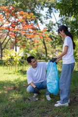 Happy young Asian students diverse volunteers with garbage bags cleaning area in the park, The concept of environmental conservation on world environment day, recycling, charity for sustainability.