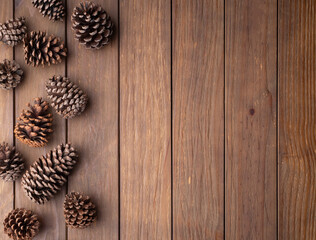 Fototapeta premium Group of pinecones over wooden table with copy space