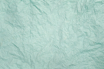 Crumpled light turquoise paper background with copy space