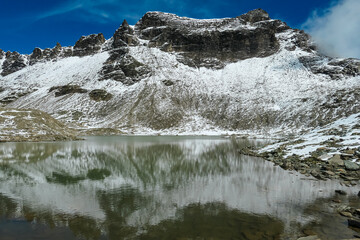 Panoramic view of alpine lake Feldsee at Feldseescharte surrounded by majestic mountain peaks of High Tauern, Goldberg group, Carinthia Salzburg, Austria. Idyllic hiking trail in remote Austrian Alps