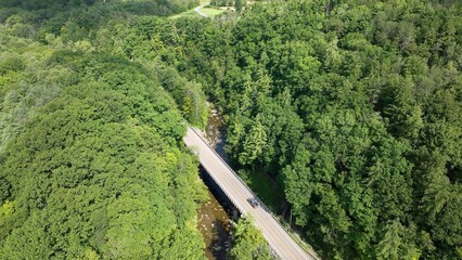 Country roads in rural New York State with green fields, trees and rivers and gently rolling hills