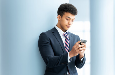 スマートフォンを使う若い外国人男性ビジネスマン