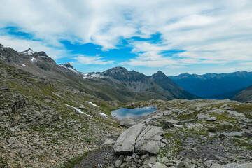 Alpine pond with scenic view of majestic mountain peak Seefeldkopf in remote wild High Tauern range, Carinthia Salzburg, Austria. Idyllic hiking trail in Goldberg group. Wilderness Austrian Alps