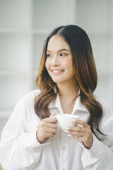 Beautiful young concentrated business woman wearing shirt using laptop while standing in modern workspace