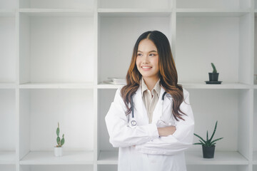 Medical concept of Asian beautiful female doctor in white coat with stethoscope, waist up. Medical student. Woman hospital worker looking at camera and smiling, studio,