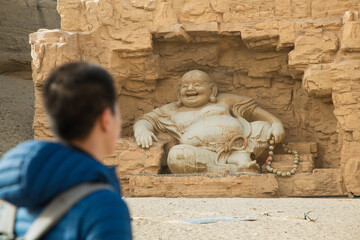 Silk Road Heritage City, Dunhuang City, Gansu Province - People standing in front of Buddha statues