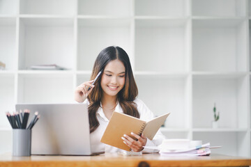 Beautiful young concentrated business woman wearing shirt using laptop while standing in modern workspace