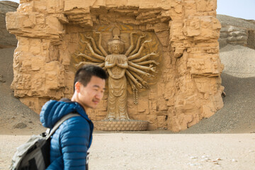Silk Road Heritage City, Dunhuang City, Gansu Province - People standing in front of Buddha statues