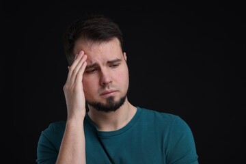 Portrait of sad man on black background