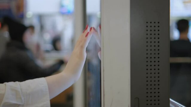 Girl using touch terminal makes a quick order through the self-service. Person swipes the screen making an order.4K
