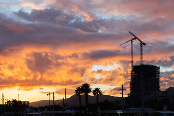 Construction Industry with Cranes, Sunset with Orange Sky