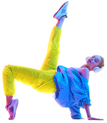Side view portrait of young girl training, raising one leg in trendy sport outfit and headphones in...