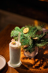 Smoothie in glass cups. Dark background with garland lights bokeh. Christmas and New Year sweet dfink and food holiday concept