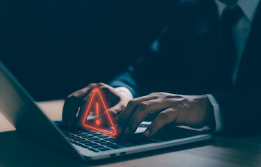 A Businessman developer working and using laptop computer with triangle caution warning sign for...