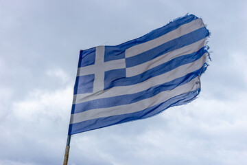 Obraz premium worn flag of Greece on strong wind 