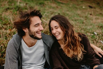 couple sitting on a grass in summer laughing