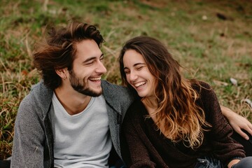 Fototapeta premium couple sitting on a grass in summer laughing