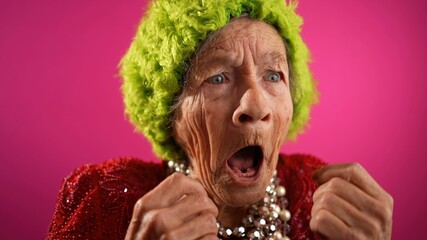Surprised happy winner fisheye view of funny elderly woman with no teeth and green hat isolated on...