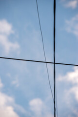 cable de electricidad sobre un cielo celeste con nubes