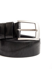 Twisted black men's leather belt on white background. Massive metal buckle closeup