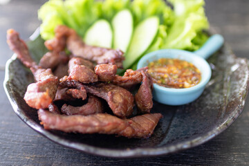 Thai fried beef jerky with Thai spicy dipping sauce (Jaew sauce). 