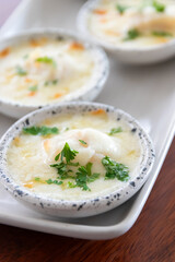 Baked scallop with cheese in mini bowl.