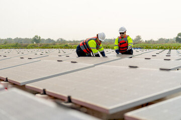 Wide shot of two technician workers sit and work on process of maintenance solar cell panel network...