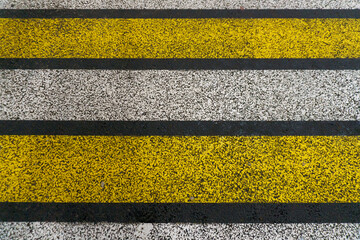 Fototapeta premium Road markings on wet asphalt. White yellow zebra for pedestrian safety. Pedestrian crossing. A copy place.