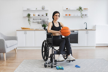 Full length portrait of Caucasian adult with mobility issues holding ball in hands before doing...