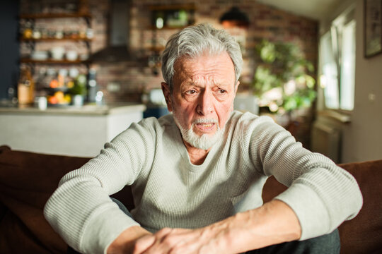 Worried Senior Man Sitting on Sofa at Home