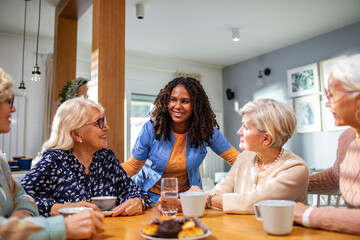 Group of senior women with a caregiver at home