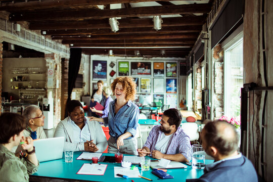 Multigenerational and diverse group of people working on a project together in a startup company office